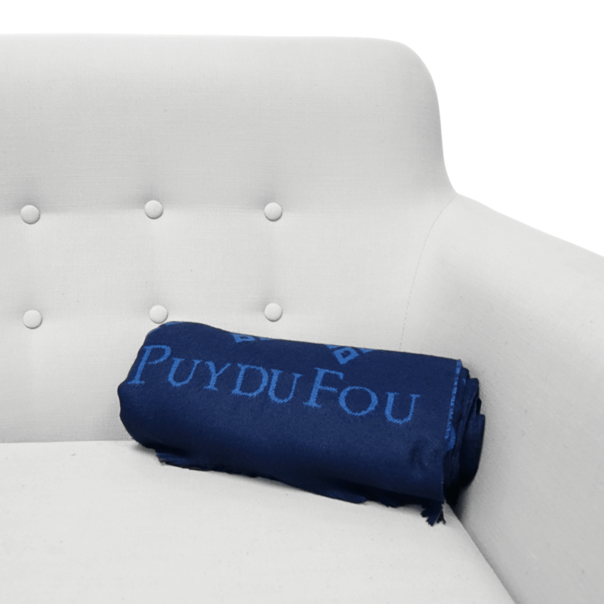 Plaid bleu marine 3 mâcles enroulé sur un canapé