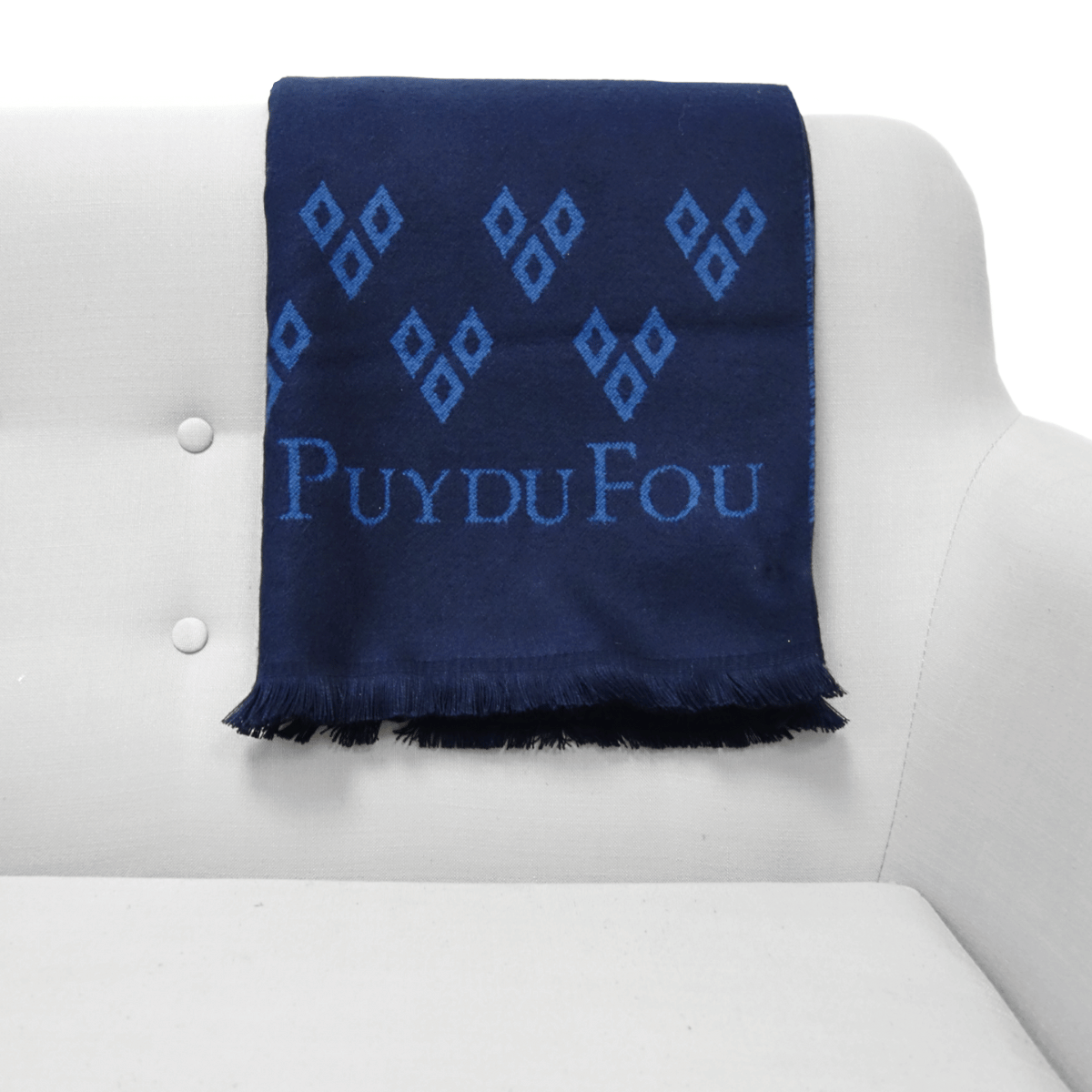 Plaid bleu marine 3 mâcles posé sur un canapé