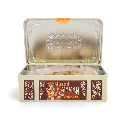 Boîte métal marron Puy du Fou ouverte, couvercle gaufré aux armes Puy du Fou et biscuits caramel visibles, inscription 