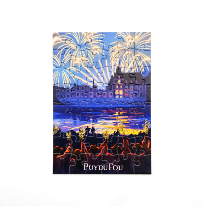 Carte postale puzzle reconstitué de la Cinéscénie : château éclairé sous un ciel embrasé de feux d'artifice, reflets sur l'eau et public