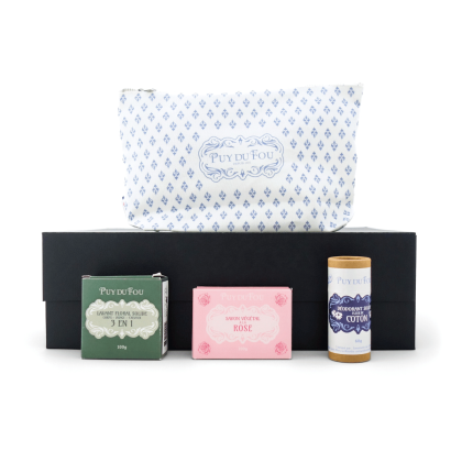 Contenu du coffret cadeau bien-être présenté sur la boîte noire : pochette 1900 bleue, savon rose, lavant solide 3 en 1 et déodorant solide fleur de coton.