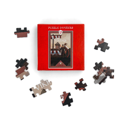 Puzzle 54 pièces Les Vikings Puy du Fou – pièces du puzzle éparpillées autour de la boîte rouge, illustration du spectacle nordique