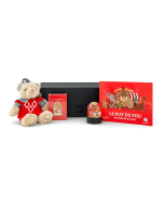 Articles du coffret cadeau jeux enfant Puy du Fou présentés devant la boîte : peluche ours chevalier, jeu de cartes, boule à neige et livre illustré.