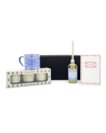 Produits du coffret Maison & Senteurs alignés devant la boîte : bougies parfumées, mini mug bleu, carnet A6 Puy du Fou et diffuseur de parfum.