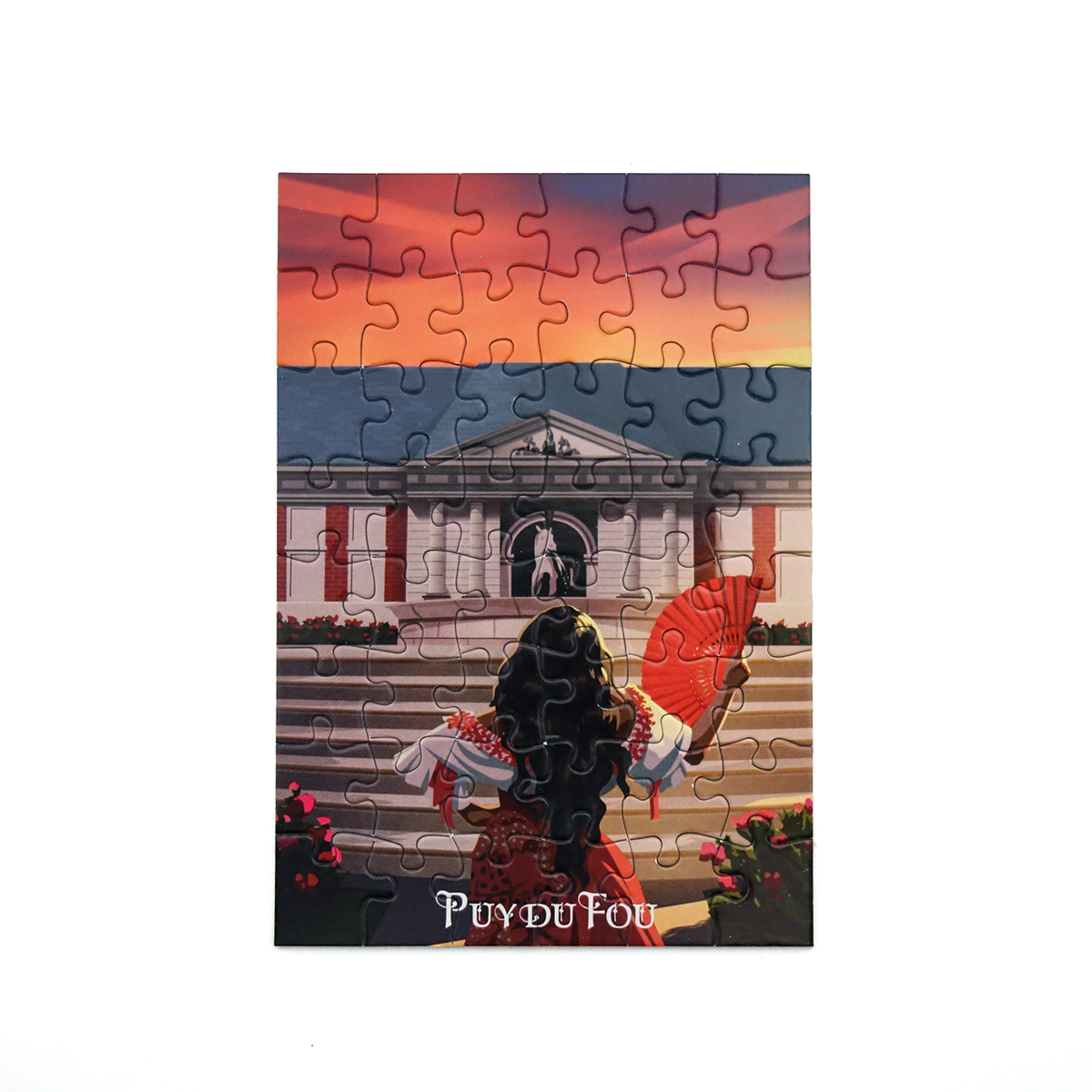 Puzzle reconstitué montrant Sérafina, personnage du spectacle des Mousquetaires, devant la façade classique du théâtre du Grand Carrossel au coucher du soleil