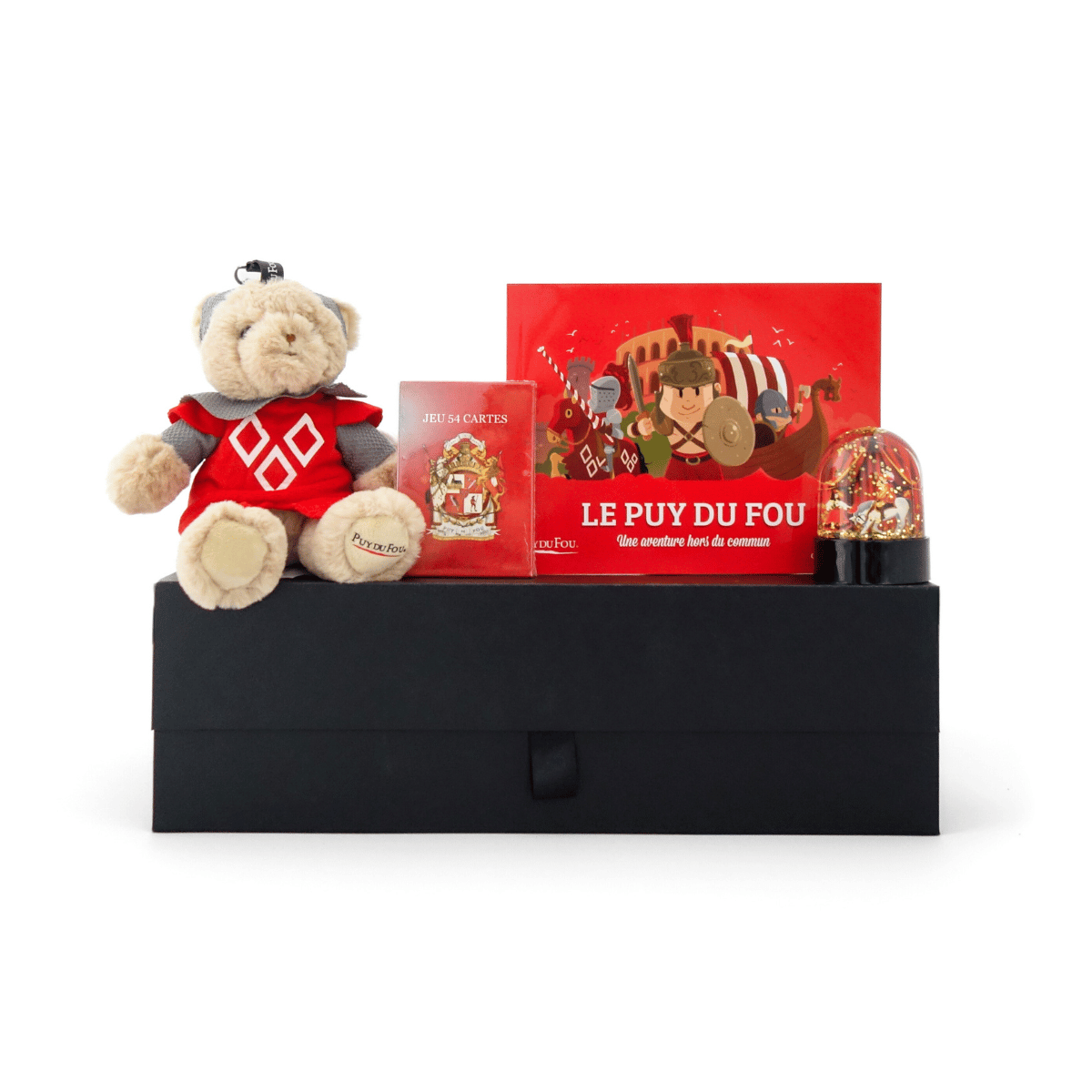 Produits du coffret cadeau jeux enfant disposés sur la boîte : peluche ours chevalier, jeu de cartes, boule à neige Mousquetaire et livre Quelle Histoire – Le Puy du Fou.
