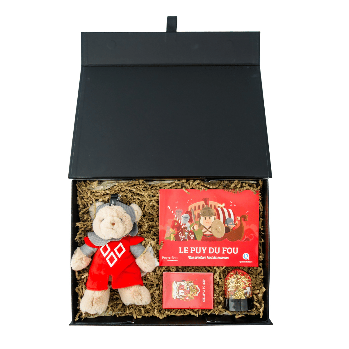Vue intérieure du coffret cadeau jeux enfant ouvert : peluche ours chevalier, jeu de cartes, livre Quelle Histoire et boule à neige rangés dans les frisures.