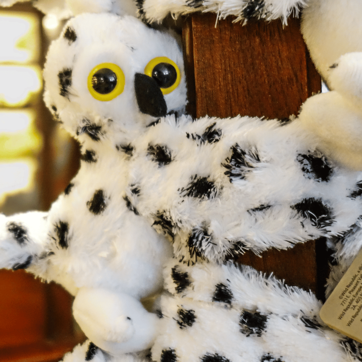 Peluche chouette clap - accroché à un poteau en bois