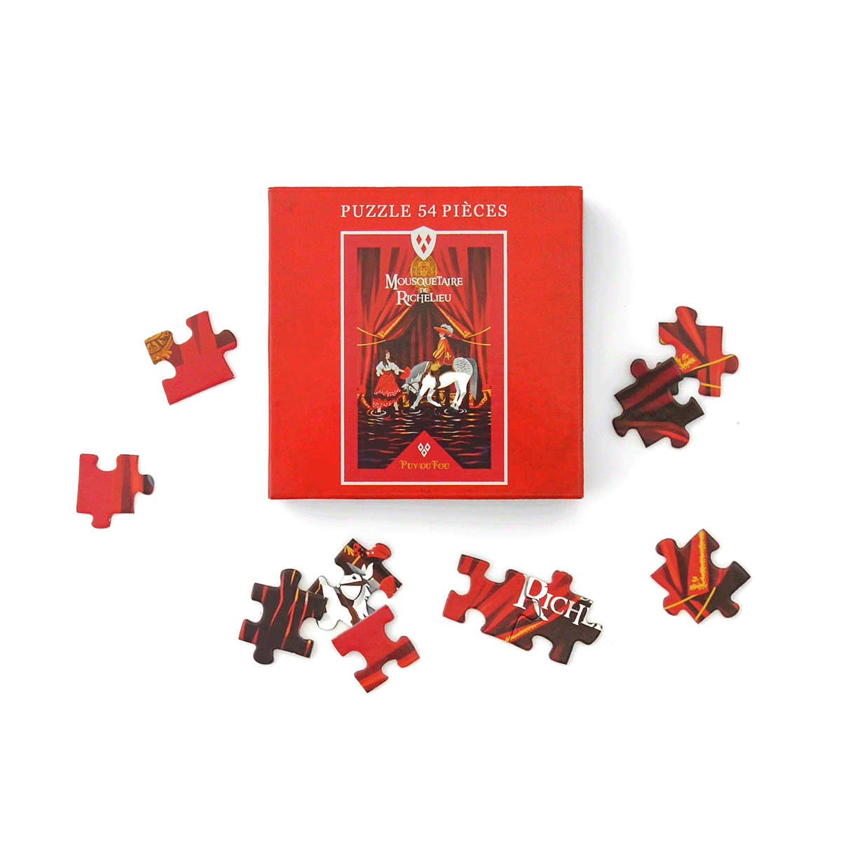 Boîte du puzzle 54 pièces Mousquetaire du Richelieu Puy du Fou entourée de plusieurs pièces du puzzle éparpillées