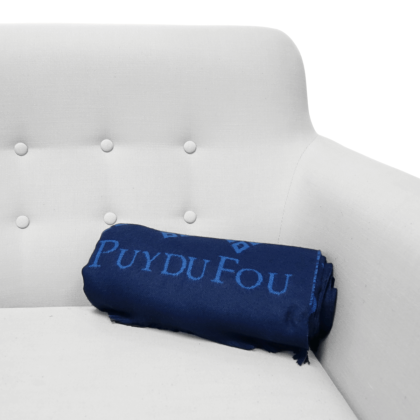 Plaid bleu marine 3 mâcles enroulé sur un canapé